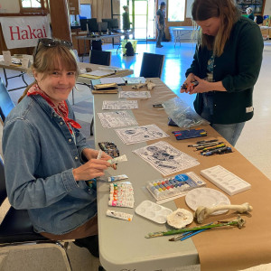 Mercedes Minck and Kelly Fretwell of The Hakai Institute prepare the art-science table at the Quadra Island Community Center as part of the Hakai Quadra Island BioBlitz 2024.